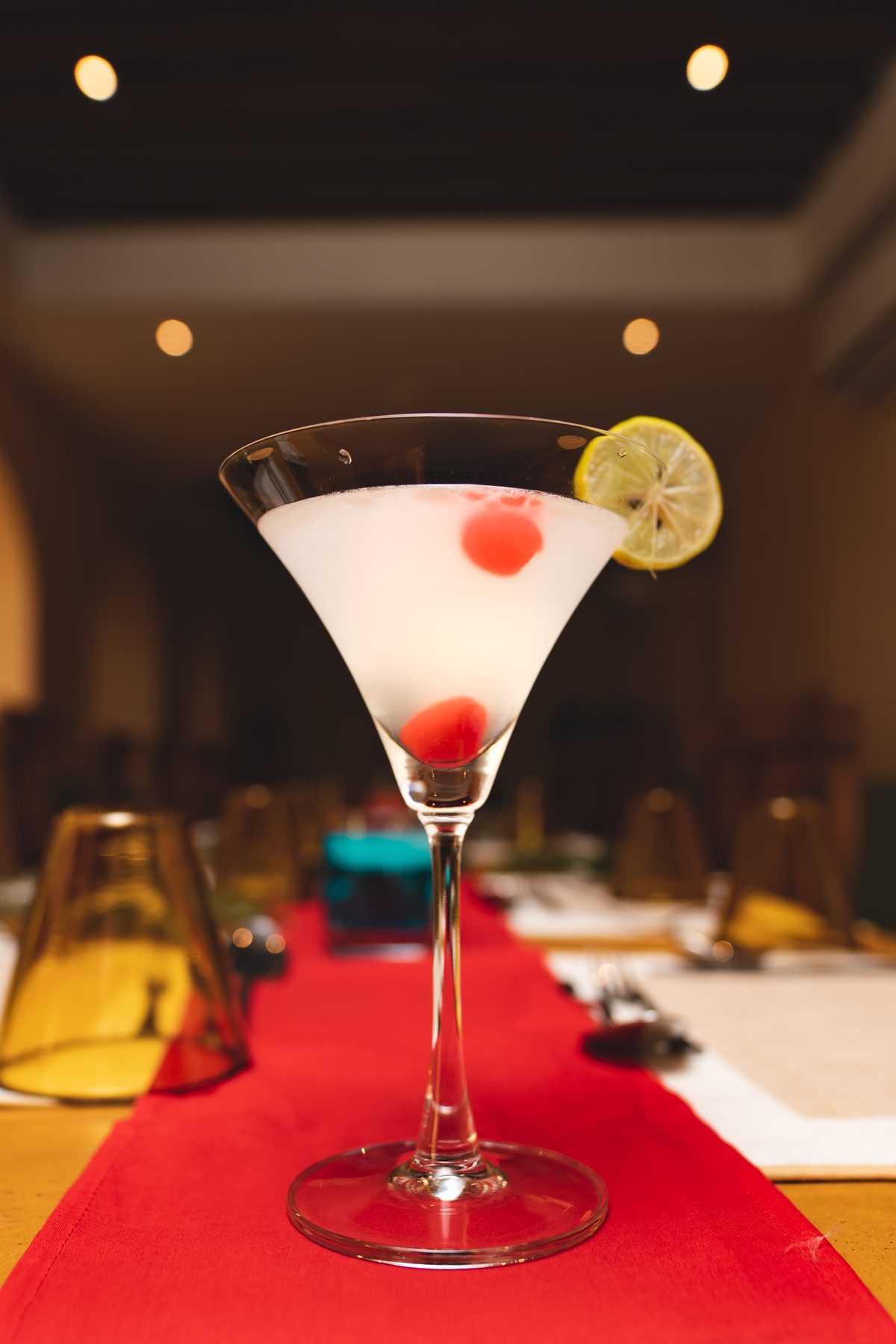 A martini garnished with a lemon wheel and cherries on the bar at Jharana Bar