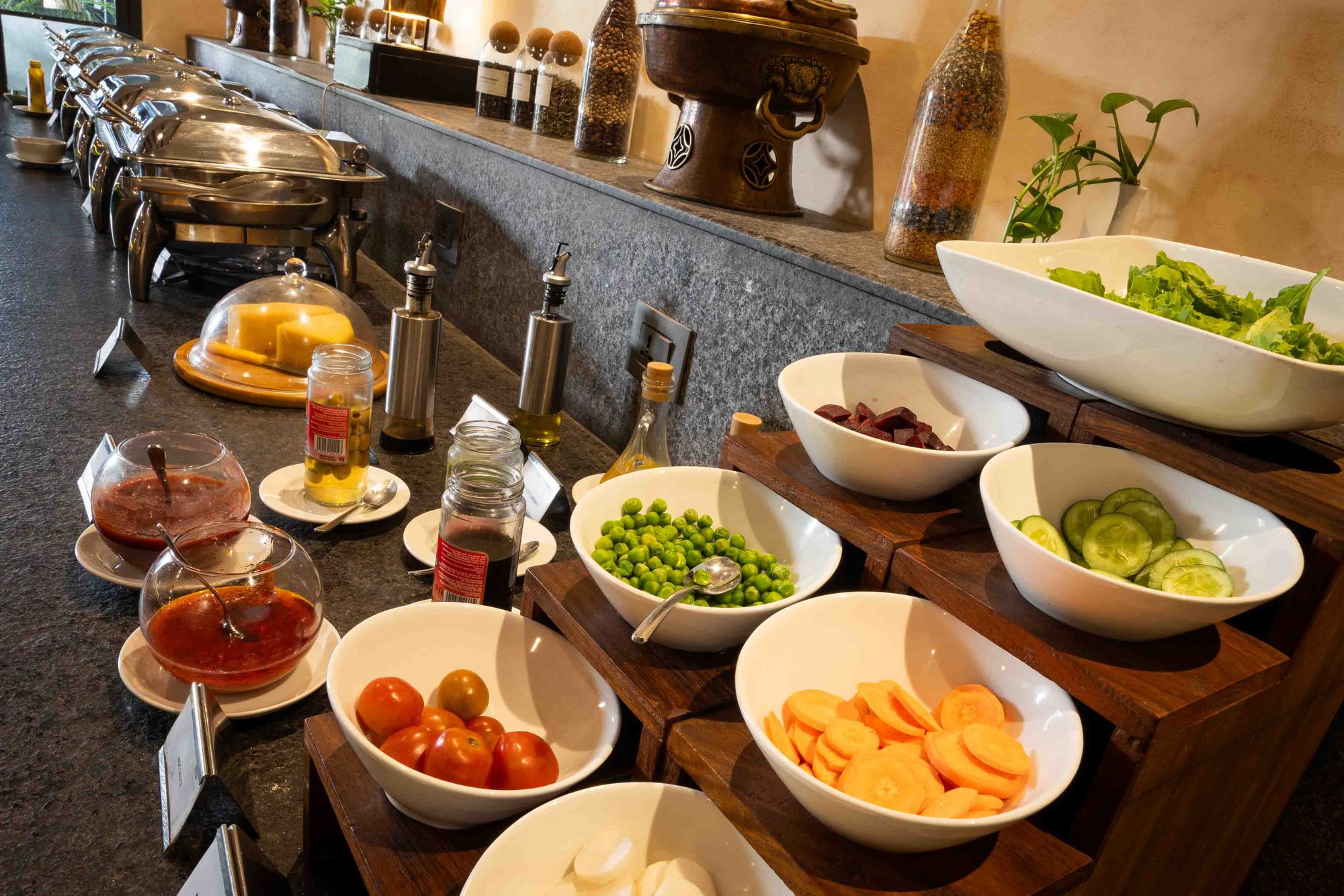 The salad and preserves spread at Chiya Pasal, with garden greens, tomatoes, and pickles