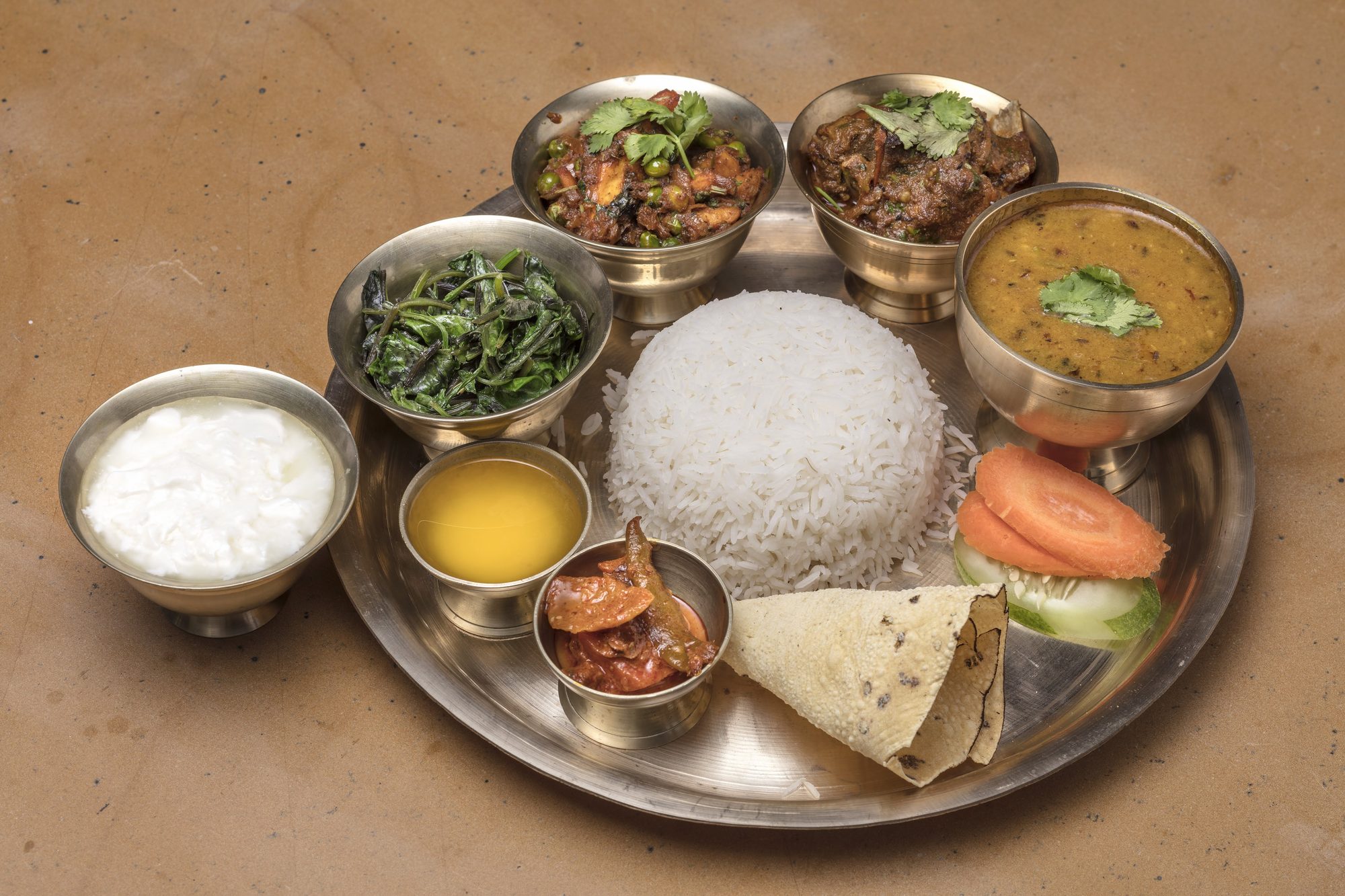 A Nepali Thali Set served on a brass platter at Chiya Pasal