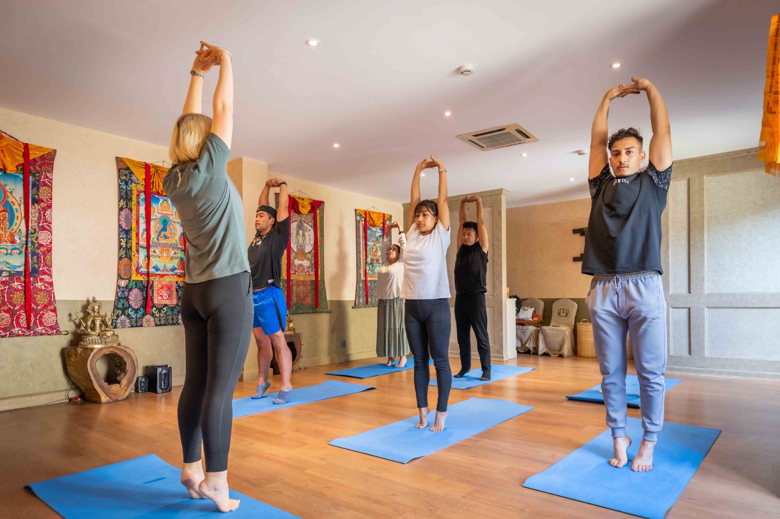 Guests in a standing stretch during daily yoga